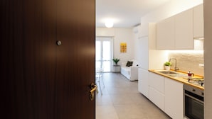 Eine moderne Küche mit weißen Schränken, einer Holzauskładung und einem eingebauten Backofen.