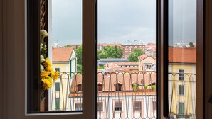 Ein Fenster mit Blick auf Gebäude und einem Balkongeländer.