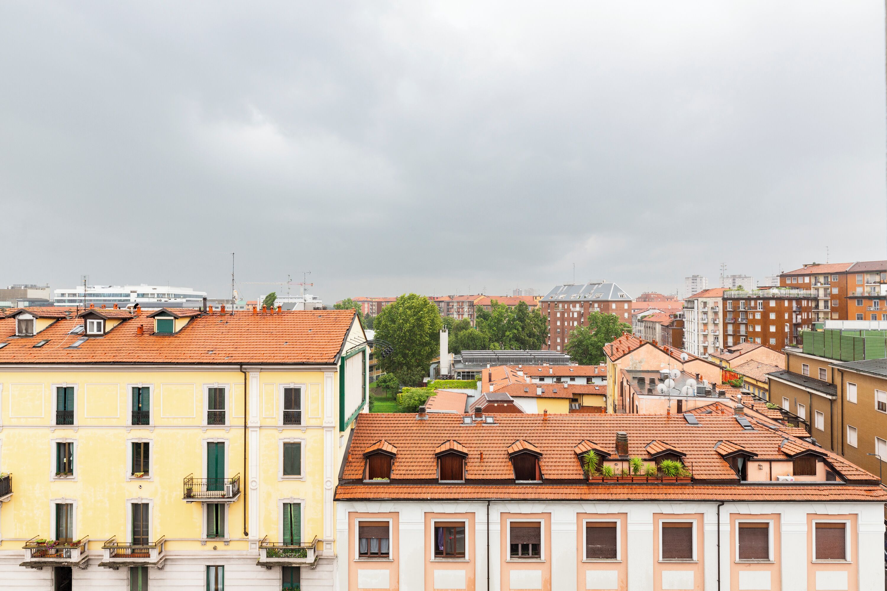 Une rangée d’immeubles à étages, tous de style architectural uniforme, avec des balcons et une ligne de toit homogène.