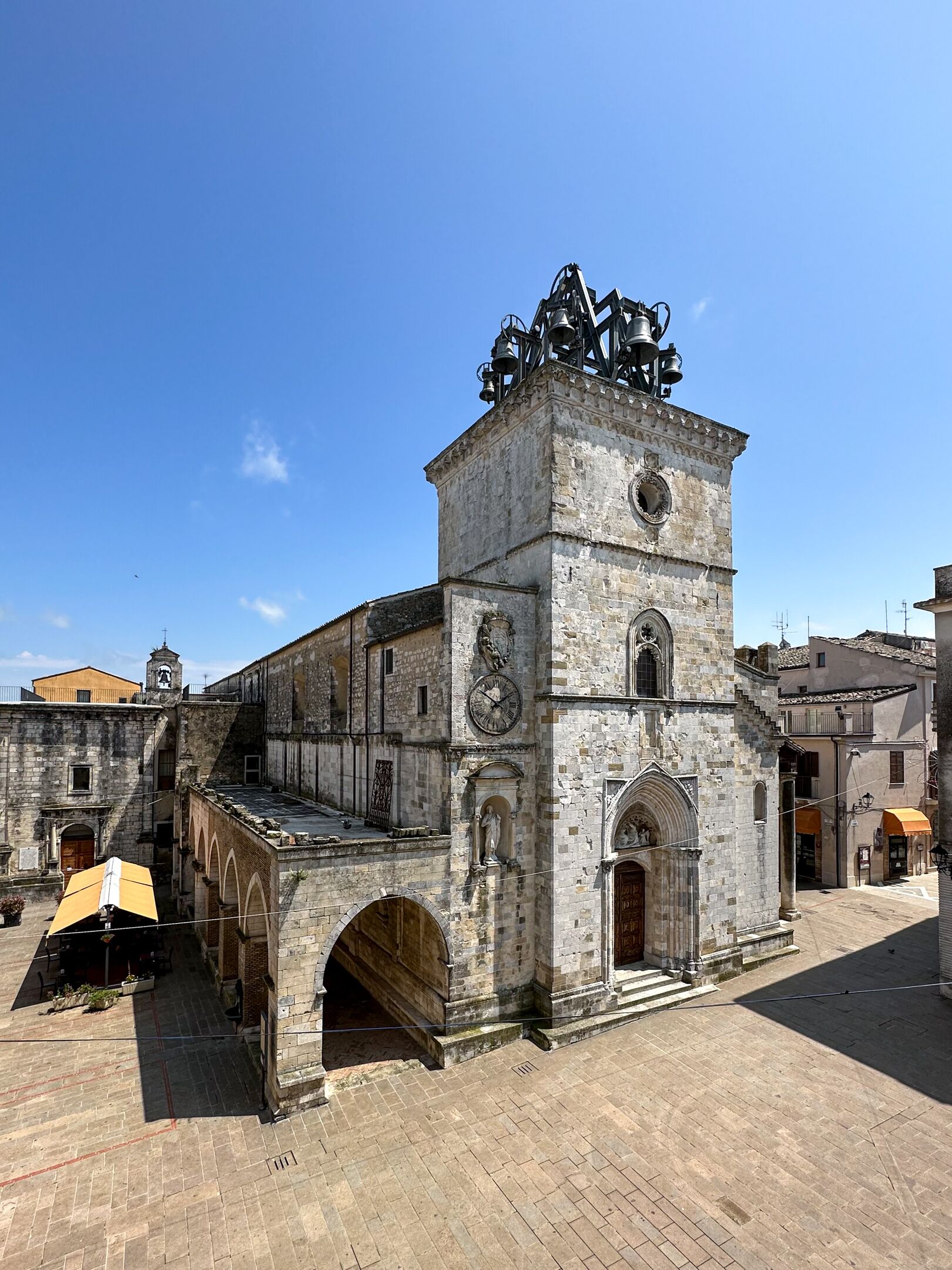 Un edificio storico in pietra con un campanile e passaggi ad arco.