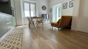 Une cuisine moderne avec des meubles blancs et un coin repas comprenant une table et des chaises.