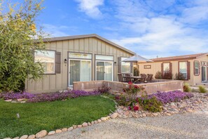 A modern house with a patio, a lawn, and a flower bed. - Ranch House View+Tub - 4 bedroom, 4 bath home on-site of Galway Downs (Temecula)
