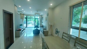 A spacious living area with a dining table, a sofa, and a TV. - Villa Royal Lotus Ha Long (Hạ Long)
