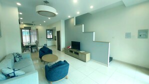 A modern living room with a sofa, a coffee table, and a TV on a stand. - Villa Royal Lotus Ha Long (Hạ Long)