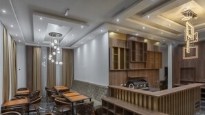 Un interior de restaurante moderno con mobiliario de madera, suelos de mármol e iluminación contemporánea.