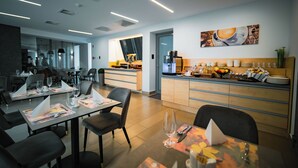 Un restaurante moderno con una barra central, mesas para comer y sillas.