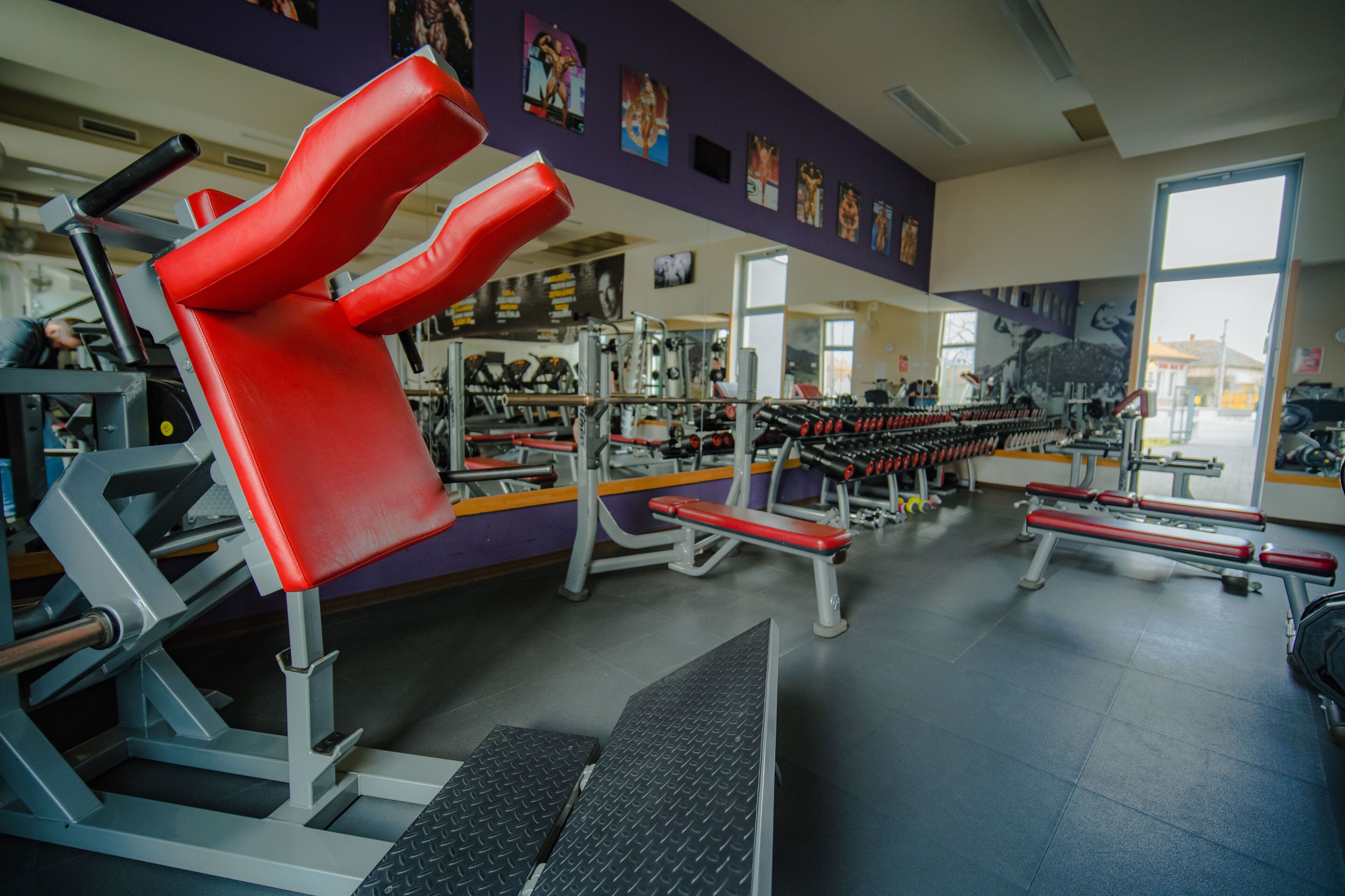 A gym with various exercise equipment, including benches and weight machines.