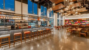 A modern bar area with a long counter, stools, and a variety of bottles. - Wink Tuy Hoa Beach, Unscripted by Hyatt - 24 Hours stay (Tuy Hoa)