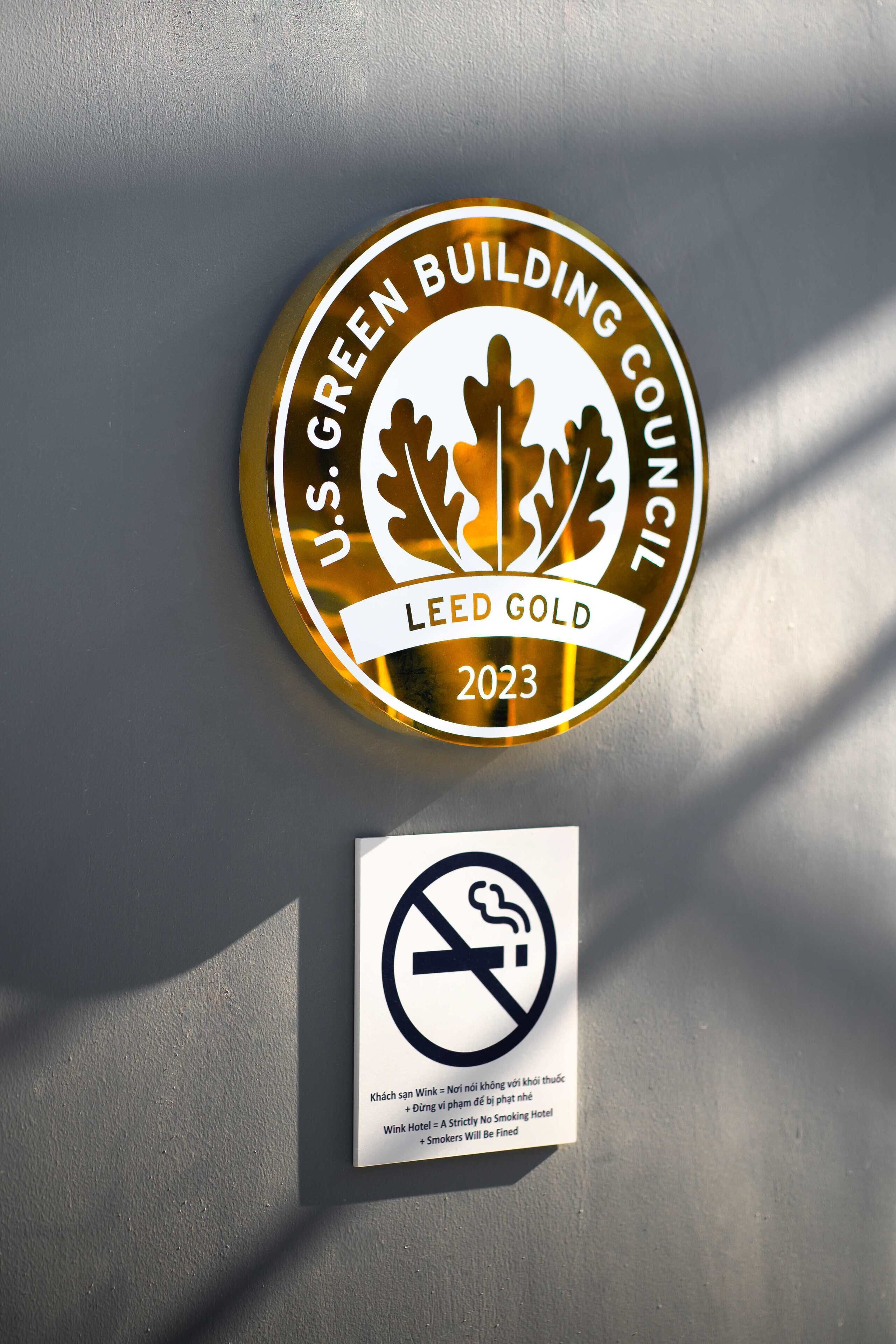 A circular emblem with "U.S. GREEN BUILDING COUNCIL LEED GOLD 2023" and a no-smoking sign below it.