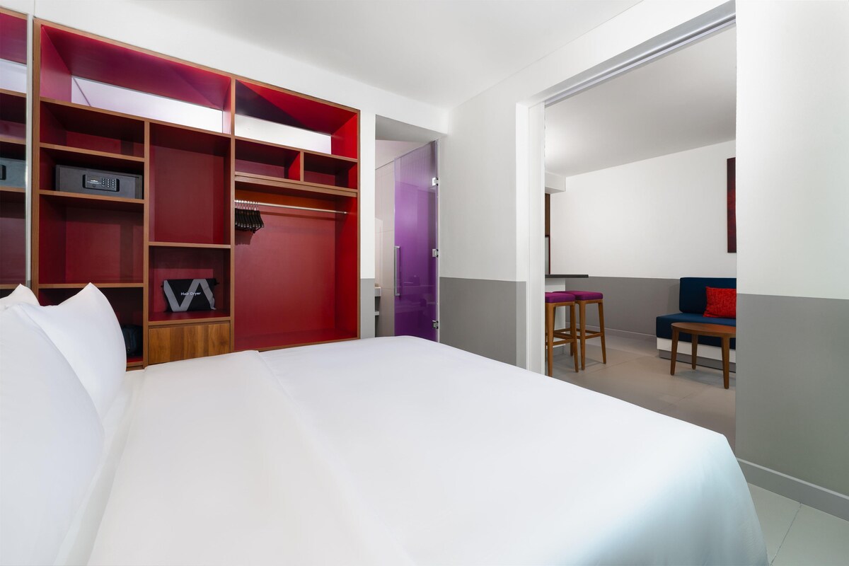 Une chambre d’hôtel comprenant un lit, une armoire, un bureau et une chaise.