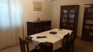 A dining room with a table set for four, a bookshelf, and a certificate on the wall. - B&B Villa Trotter (Mira)