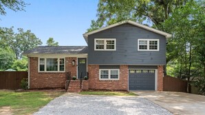 A two-story house with a brick facade, a dark gray upper level, and a front garage. - The Juke Joint: Game Room, Pet-Friendly BHM Home! (Birmingham)