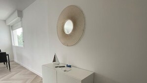 Una habitación moderna con un armario blanco, un espejo decorativo y un tapete estampado.