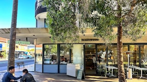 A cafe named Blackwood with outdoor seating, a visible menu board, and a clear view of the street. - Stylish Sun Drenched North Bondi Beach Oasis (North Bondi)