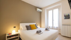A bedroom with a bed, bedside tables, a radiator, and a window. - notaMi - Happy Stay - Naviglio Grande (Milan)