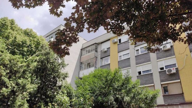 A multi-story residential building with balconies, air conditioning units, and a mix of window styles. - Sasa Apart (Beograd)