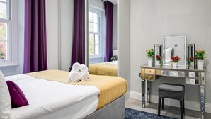 Una habitación de hotel con cama, espejo, escritorio y ventana.