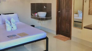 A hotel room with a bed, a bedside table with a white bowl, a mirror, and a door. - Hannas Inn El Nido Palawan  (El Nido)