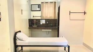 A hotel room with a bed, a bedside table, a mirror, and a bathroom visible through an open door. - Hannas Inn El Nido Palawan  (El Nido)