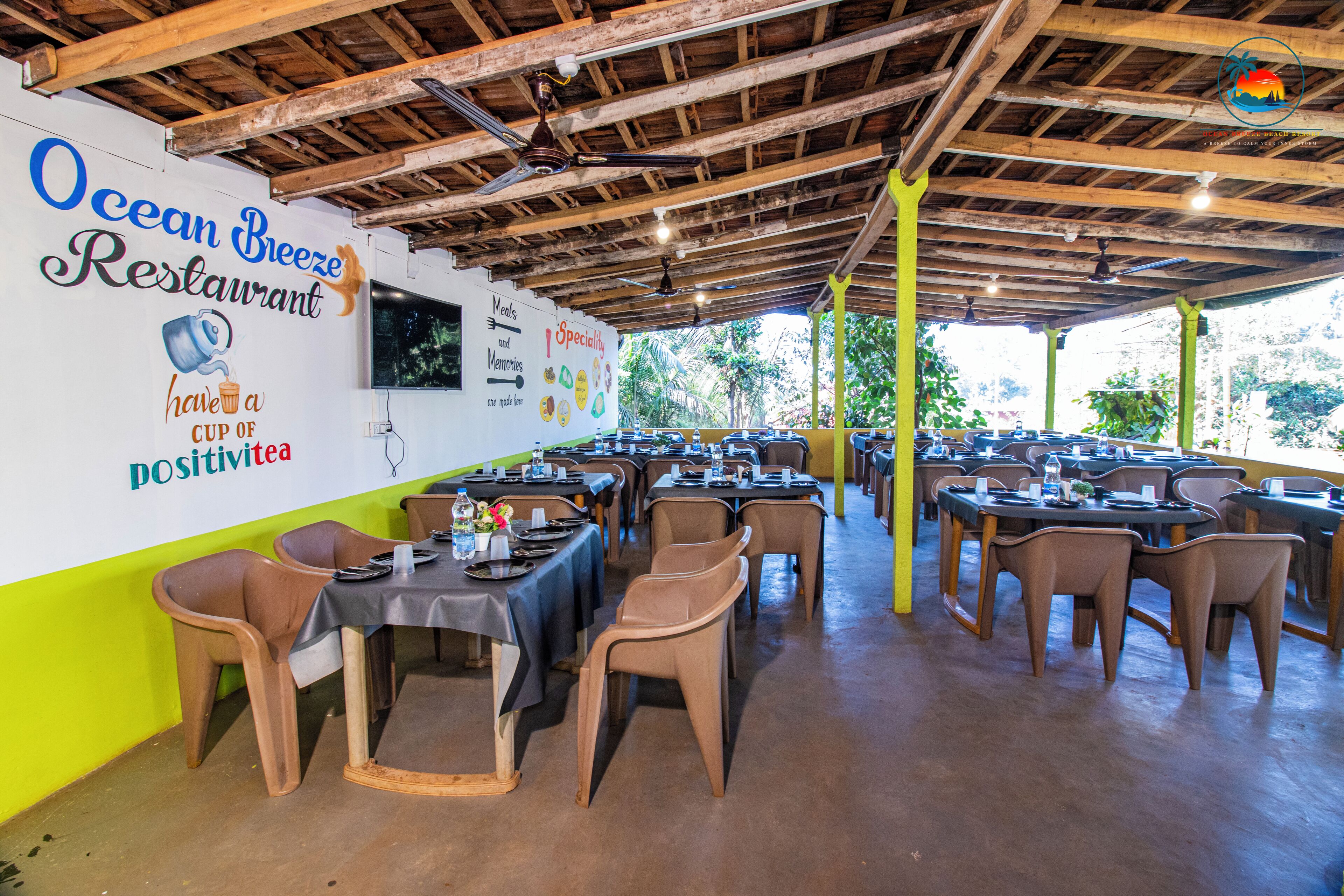 Un restaurant avec un plafond en bois et des tables dressées pour le service.