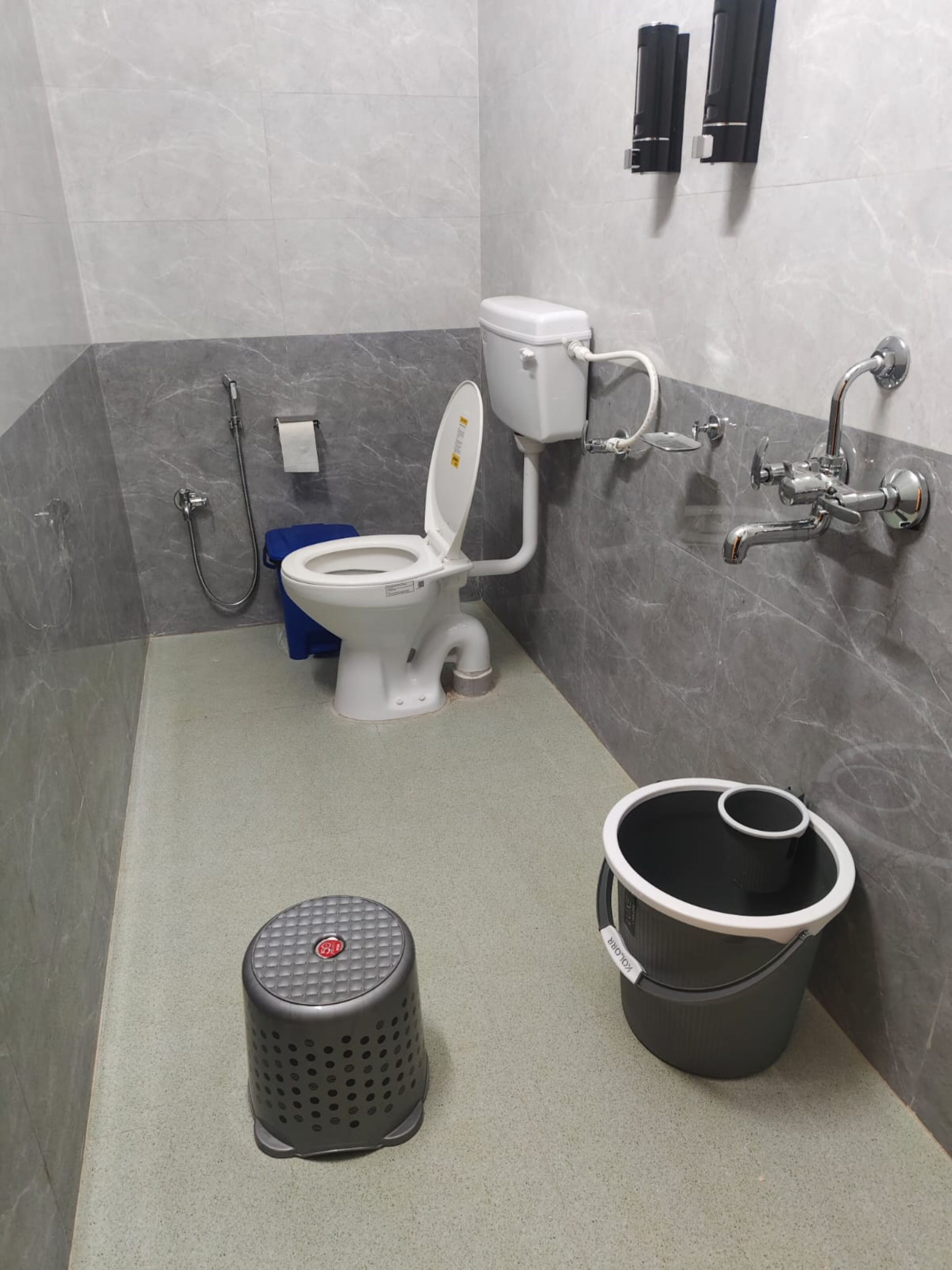Une salle de bain équipée de toilettes, d’un bidet et d’une petite poubelle.