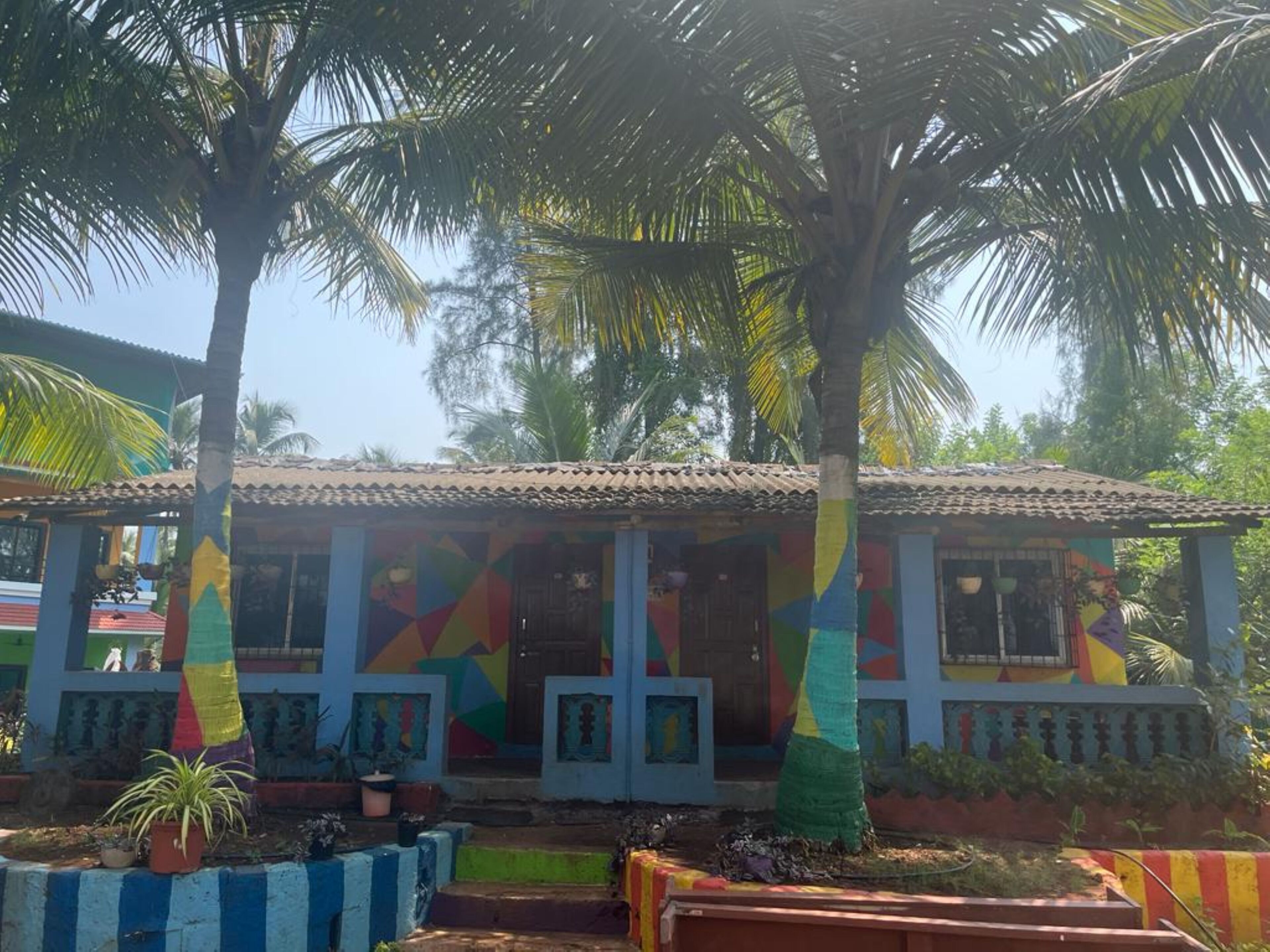 A colorful building with a tiled roof, surrounded by palm trees.