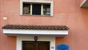 A building entrance with a double door, a small window above, and a blue sign indicating a nearby airport. - Apartment*3 Virgilio Lamezia Airport "FANTASIA" (Santa Eufemia Lamezia)