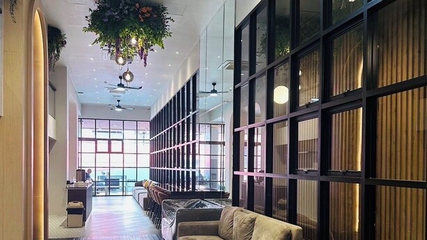 A modern interior with a long corridor, seating area, and a dining space with hexagonal patterned flooring. - 14 Sathorn hotel (Bangkok)