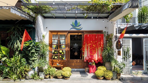 Een etalage met een bord waarop 'Flower Beach Stay & Coffee' staat.