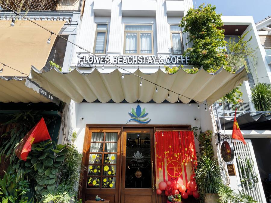 A building with a sign reading "Flower Beach Stay & Coffee".