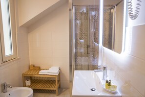 Klassieke tweepersoonskamer | Badkamer | Een douche, een haardroger, een bidet, handdoeken