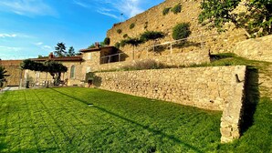 A stone building with a grassy courtyard, a staircase, and a small garden area. - San Michele al Castello (Castiglion Fiorentino)