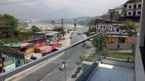A street view with buildings, a bridge, and mountains in the background. - Hotel Moon Rise (Srinagar)