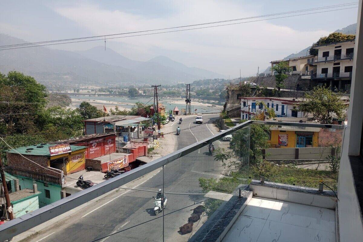 Une vue de rue avec des bâtiments, un pont et des montagnes en arrière-plan.