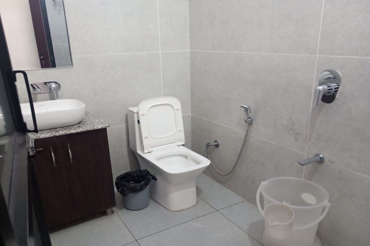 A bathroom with a toilet, sink, and shower.
