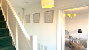 A staircase leading to a room with a radiator, a wooden coffee table, and a lamp. - Spacious Family Home (Manchester)
