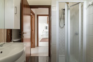 Relax in a spacious bathroom with a bathtub and glass-enclosed shower.