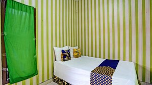 A room with a bed, striped wallpaper, and a green curtain. - Hotel O Gang Songo Syariah HomestayNearWisata Osing (Rogojampi)