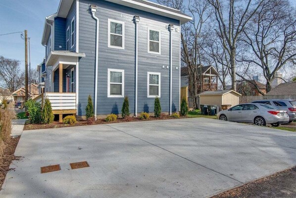 A two-story residential building with a front porch, a garage, and a driveway. - Rooftop Fire Pit | 2 mi to Brdwy | Modern Vibes (Nashville)