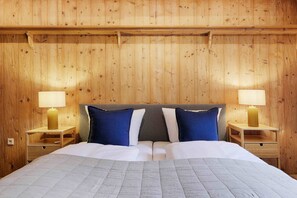 A wooden-paneled room with a bed, two bedside tables, and two lamps. - homie stay badgasse - am Main mit Dachterrasse (Ochsenfurt)