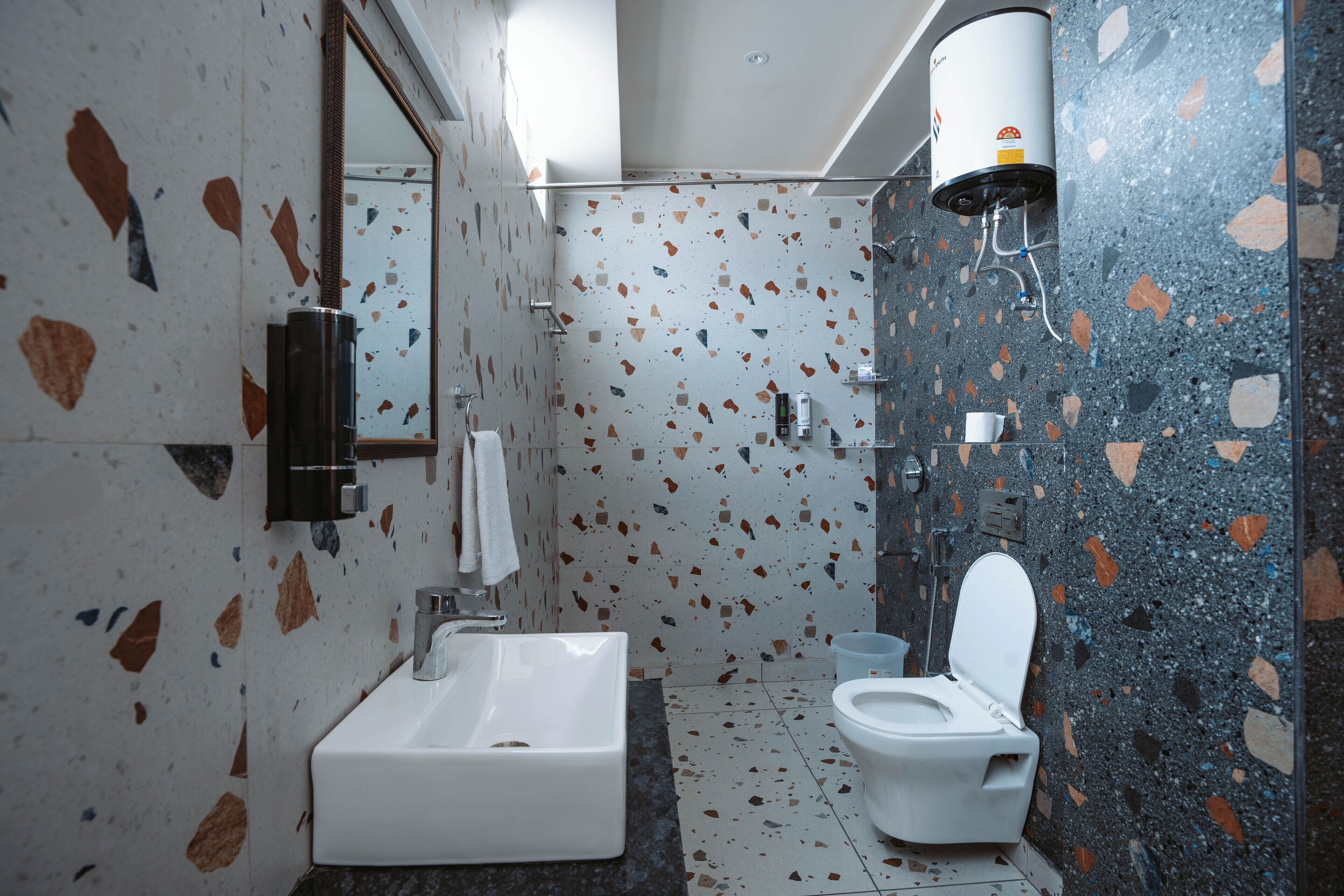 A bathroom with a white sink, a toilet, and a wall-mounted heater.