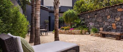 A modern outdoor seating area with a lounge chair, a bench, and a table with a book.
