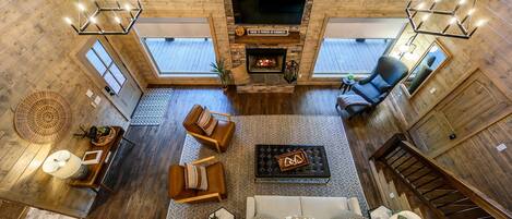 A spacious living area with a fireplace, comfortable seating, and a large TV screen.