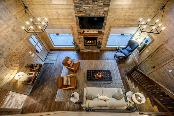 A spacious living area with a fireplace, comfortable seating, and a large TV screen.