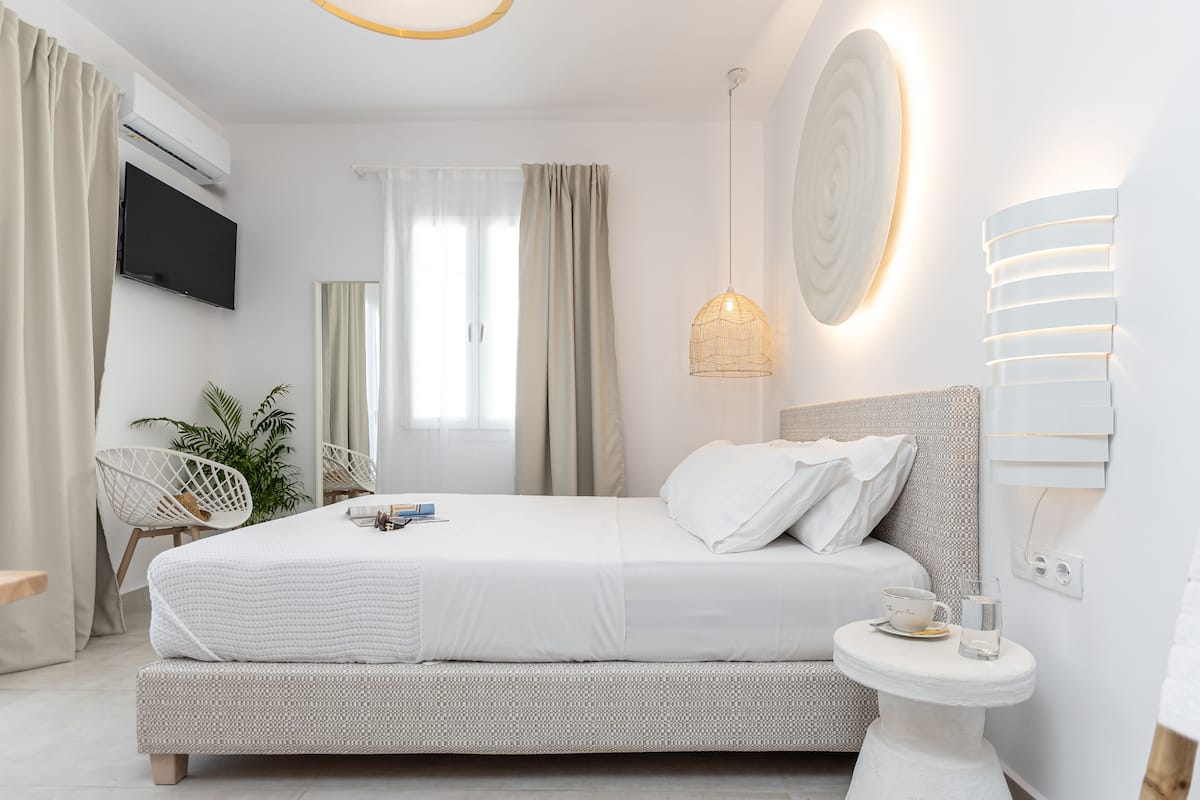 A modern bedroom with a bed, bedside table, and a TV.