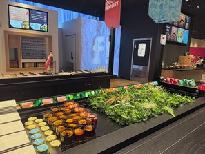 En buffetvogn med forskellige madmuligheder, et køleelement og et udvalg af friske krydderurter.