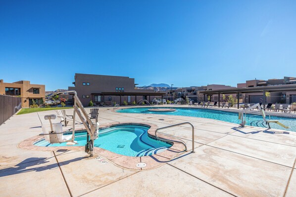Relax by the pool surrounded by lounge chairs and umbrellas.
