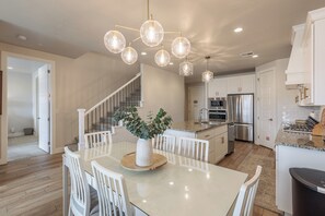 Enjoy meals in the well-lit kitchen with a central island, oven, and dining area with a large table.