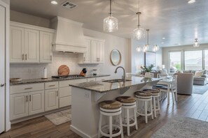 Enjoy cooking in this well-lit kitchen with a central island, bar stools, and granite countertops.