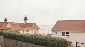 A residential area with houses, a wooden fence, and a view of the sea.